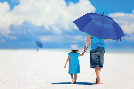 Dad & daughter on beach with umbrella